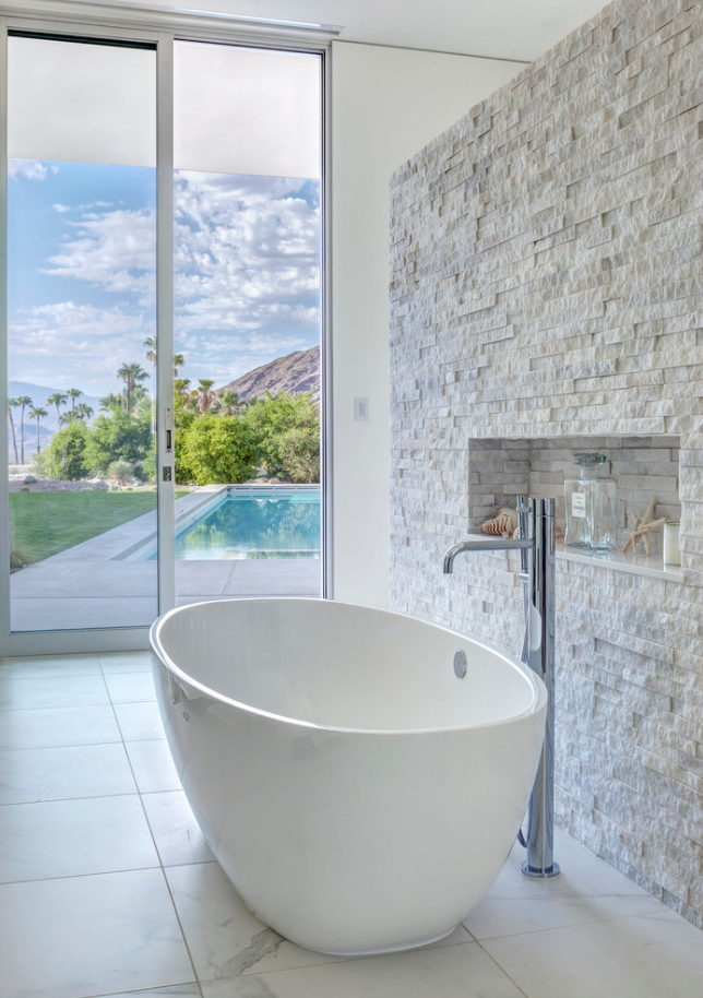 This bathroom has a chiseled quartz wall with a nook for toiletries.  Would you …